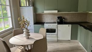 a kitchen with white appliances and a table with chairs at Glaskogen Holiday Homes in Glava +24 photos