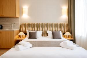 a hotel room with a large bed with white pillows at Résidence Monceau Jadin in Paris