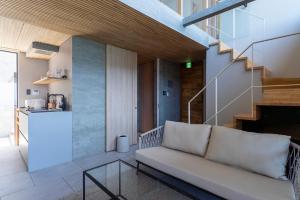 a living room with a couch and a glass table at KONA OCEAN Club in Awaji