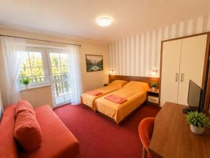 a bedroom with a bed and a couch at Pensjonat PISZ in Pobierowo
