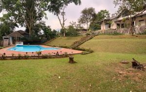 a house with a swimming pool in a yard at Hotel Kay Terrace in Campaka
