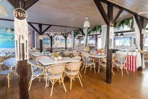 a restaurant with tables and chairs in a room at Pensjonat PISZ in Pobierowo