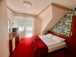 a hotel room with a bed and a window at Pensjonat PISZ in Pobierowo