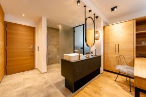 a bathroom with a sink and a mirror at Arlbergerhof Vital in Weissensee +29 photos