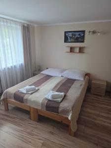 a bedroom with a large bed with two towels on it at Willa AGAT in Ciechocinek