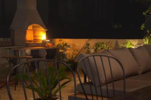 a patio with a couch and a table and a fireplace at PaCha Boutique house in Novalja