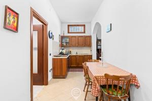 a kitchen with a table and chairs and a kitchen with a counter at Estay - Zoe&Perla - Exclusive vacation near the beach in S'archittu Cuglieri +21 photos