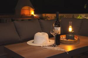 a hat and a bottle of wine and a candle on a table at PaCha Boutique house in Novalja