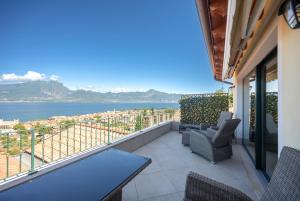a balcony with chairs and a view of the water at ApartmentsGarda - Villa Giada in Torri del Benaco
