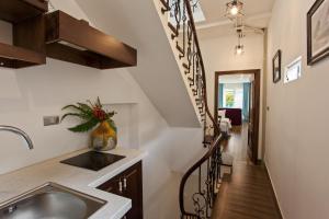 a kitchen with a sink and a spiral staircase at Hanoi Maro Hotel in Hanoi