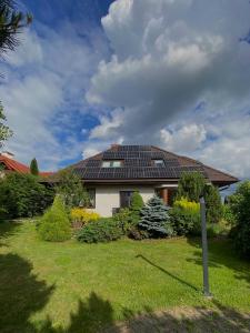 a house with a solar roof on top of a yard at Cozy Garden Apartment Near Krakow - Free Parking in Gaj