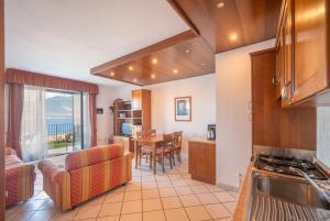 a kitchen and living room with a table and chairs at ApartmentsGarda - Villa Giada in Torri del Benaco