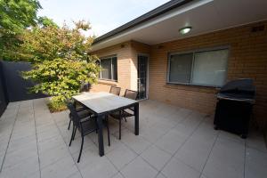 a table and chairs on a patio next to a building at Apartments by Townhouse in Wagga Wagga