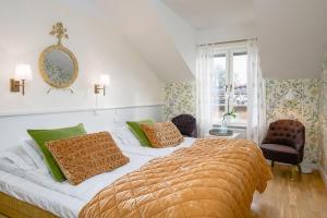 a bedroom with a large bed with green and orange pillows at Trosa Stadshotell & Spa in Trosa +41 photos