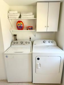 a small laundry room with a washer and dryer at Peaceful Redding Cottage Retreat in Redding