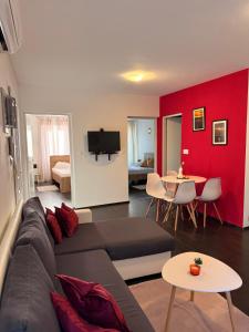 a living room with a couch and a red wall at Lalya App in Vodnjan