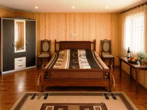 a bedroom with a bed and a table and a mirror at Sarag Family Guesthouse Svaneti in Mestia +46 photos