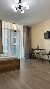a bedroom with a bed and a table and a window at Aqua Batumi 44 in Batumi