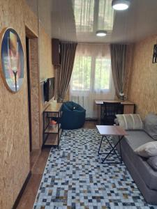 a living room with a couch and a table at Гостевой дом Chimgan Apple Garden in Chimgan