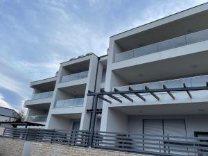 a white apartment building with a balcony at Apartma LAVANDA 3 Šilo in Šilo