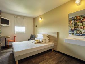 a hotel room with a bed and a sink at hotelF1 Laval in Changé