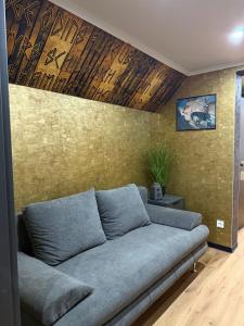 ein Wohnzimmer mit einer Couch vor einer Wand in der Unterkunft Gasthaus Eiserner Löwe in Brattendorf