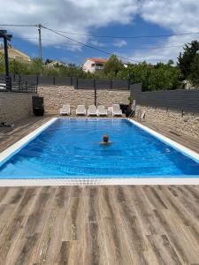 a person swimming in a swimming pool at Apartma LAVANDA 3 Šilo in Šilo