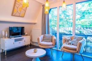 a living room with two chairs and a television at Chalet Lupin in Durbuy