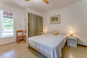 a bedroom with a bed and a chair and a window at Studio meublé in Saint-Rémy-de-Provence