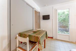 a dining room with a table and a window at Studio meublé in Saint-Rémy-de-Provence