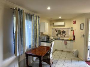 a small kitchen with a wooden table in a room at Mount Barker Valley Views Motel & Chalets, Western Australia in Mount Barker