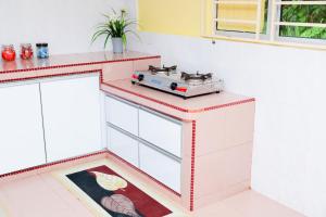 a kitchen with a stove on top of a counter at Aisya homestay jerteh in Jertih