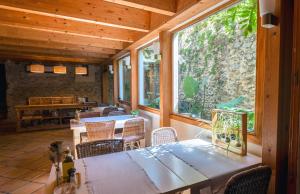a room with a table and chairs and a large window at Hotel Boutique Niu de Sol - Designed for Adults in Palau-Saverdera