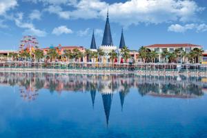 a view of a resort with its reflection in the water at Granada Luxury Belek - Family Kids Concept in Belek