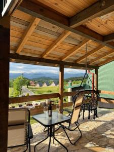 a patio with a table and chairs and a swing at HRID - vikendica u prirodi in Šavnik
