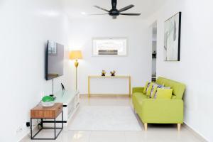 a living room with a green couch and a table at Aisya homestay jerteh in Jertih