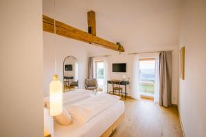 a bedroom with a large bed and a desk at Gut Herzogberg in Sonntagberg