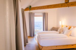 two beds in a room with a window at Gut Herzogberg in Sonntagberg