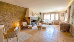 a living room with a stone wall and a fireplace at Hotel Boutique Niu de Sol - Designed for Adults in Palau-Saverdera
