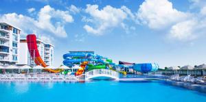 a water park with a water slide in the water at Greenwood Suites Resort in Lara