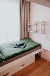 a bedroom with a bed with green sheets and a window at Apartment Slupečná Lipno in Kramolín