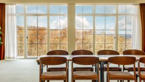 a table and chairs in front of a large window at Marienlyst Strandhotel in Helsingør