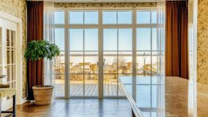 a large glass door in a living room with a table at Marienlyst Strandhotel in Helsingør