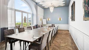 a dining room with a long table and chairs at Marienlyst Strandhotel in Helsingør