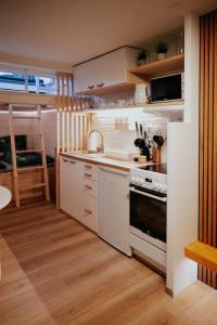 a kitchen with white cabinets and a stove top oven at Apartment Slupečná Lipno in Kramolín