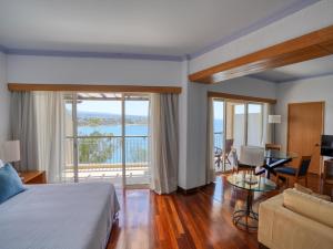 a hotel room with a bed and a living room at Thalassa Boutique Hotel & Spa in Paphos +73 photos