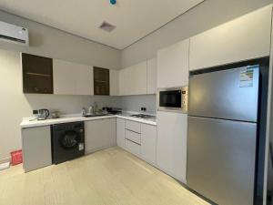 a kitchen with white cabinets and a stainless steel refrigerator at شقة O&Me الفندقية in Medina