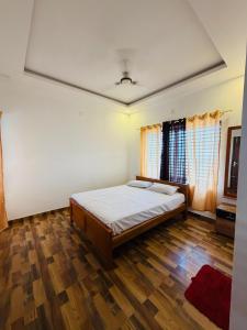 a bedroom with a bed and a wooden floor at BIG INN Resort in Mattanūr