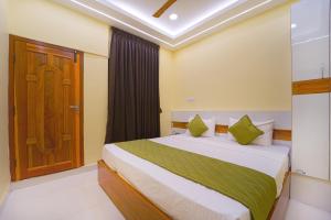 a bedroom with a bed and a wooden door at I&S Residency in Rāmanāthapuram