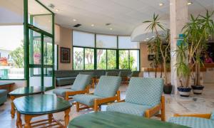 a waiting room with chairs and tables and windows at ALEGRIA Pino Alto in Miami Platja